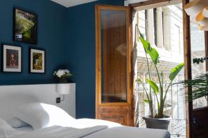1 dormitorio con paredes azules y puerta de madera en Hostal Sol y K, en Barcelona