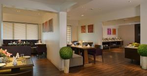 a restaurant with tables and chairs and a dining room at Residency Sarovar Portico in Mumbai