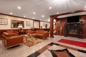 a lobby with a living room with a fireplace at Ramada by Wyndham Albert Lea in Albert Lea