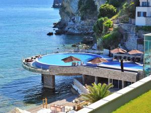a swimming pool in the water next to the ocean at Avala Resort & Villas in Budva