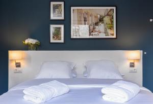 
a bed with two pillows and two pictures on the wall at Hostal Sol y K in Barcelona
