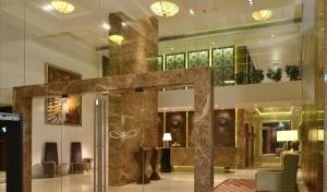 a lobby of a hotel with a staircase and chairs at Residency Sarovar Portico in Mumbai