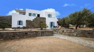 a large white house with a stone wall at Villa Filitsa in Platis Gialos