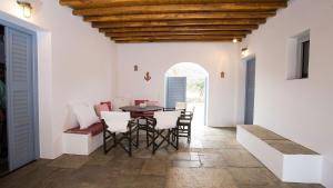 a dining room with white walls and a table and chairs at Villa Filitsa in Platis Gialos