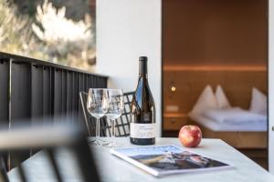 a bottle of wine and an apple on a table at Apartment 39012 in Merano