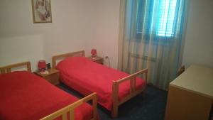 a small room with two beds and a window at Apartman Dino in Roč