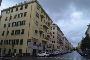 a large yellow building on a street with cars parked at Il Genovino in Genoa