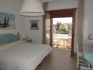 a bedroom with a bed and a table and a balcony at Camera con Vista in Oristano