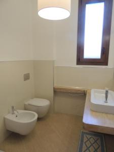 a bathroom with a white toilet and a sink at Camera con Vista in Oristano