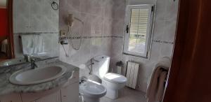 La salle de bains est pourvue d'un lavabo et de toilettes. dans l'établissement Pensión Toranda, à Niembro