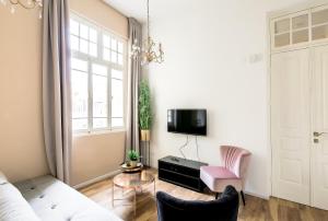 uma sala de estar com um sofá, uma mesa e uma televisão em House of Palm - One of a Kind em Tel Aviv