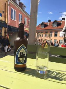 una botella de cerveza sentada en una mesa junto a un vaso en Toftavägen 325 Semesterbostad, en Tofta