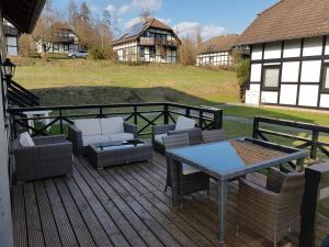 um deque com sofás, uma mesa e cadeiras em Apartment Am Sternberg 236 em Frankenau