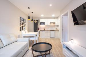 a living room with a white couch and a table at LA PETITE MAISON DE SUSANNA in Pas de la Casa