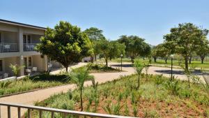 una pasarela frente a un edificio con árboles en ANEW Resort White River Mbombela en White River