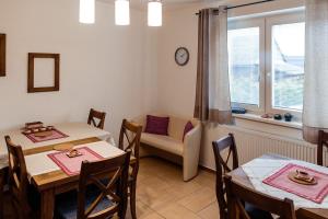 uma sala de jantar com duas mesas e um sofá em Apartmány Hrady em Zuberec
