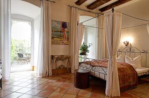 a bedroom with a canopy bed and a patio at Hotel Orphée Andreasstadel in Regensburg