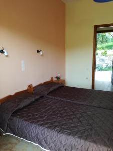 a bedroom with a bed with a black comforter at Tony studio & apartments in Laganas