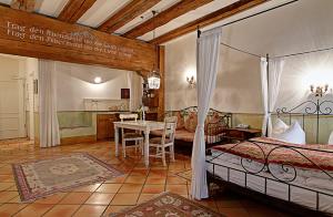 ein Schlafzimmer mit einem Bett und einem Tisch darin in der Unterkunft Hotel Orphée Andreasstadel in Regensburg