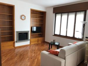 - un salon avec un canapé et une télévision dans l'établissement Veneto Civico 17, à Sarnico