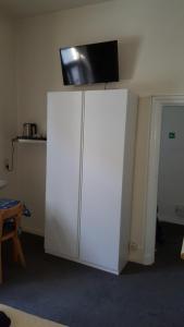 a white cabinet with a tv on top of it at Guest house Adonis in Bruges