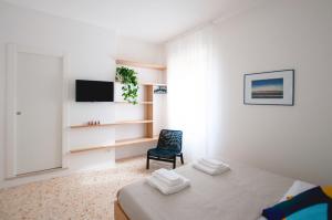 a white room with a bed and a chair at Casa27 in Terracina