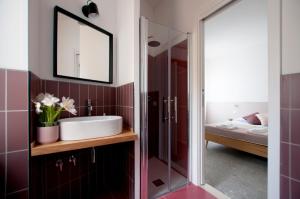 a bathroom with a sink, toilet and mirror at Casa27 B&B in Terracina