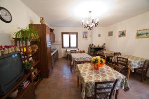 Un comedor con mesas y sillas y un televisor. en Agriturismo La Piantata, en Bolsena