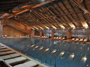 a large indoor swimming pool with chairs in it at Bianca Resort & Spa in Kolašin