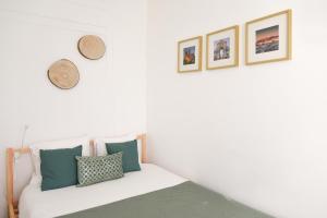 una camera da letto con pareti bianche e un letto con cuscini di Charming Apartment - Lisbon Center a Lisbona