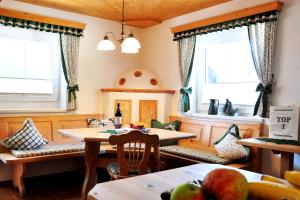 a dining room with two tables and two windows at Appartment Maurer in Oetz