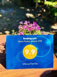 a blue sign sitting on a table with flowers at Villa la familia in Makhinjauri