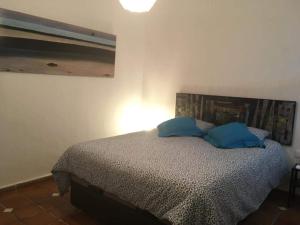 a bedroom with a bed with blue pillows on it at Casa Maria in Rota
