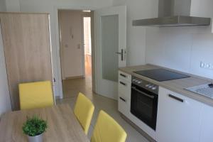 a kitchen with a wooden table and yellow chairs at Gästewohnung in Döbeln in Döbeln