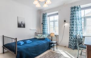 una camera da letto con un letto, una scrivania e finestre di Old City Park Apartment a Riga