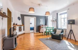 un soggiorno con una tv, una sedia e un tavolo di Old City Park Apartment a Riga