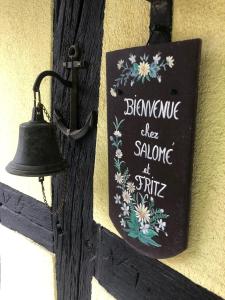 un panneau sur le côté d'un mur avec une cloche dans l'établissement chez salome et fritz, à Ingolsheim