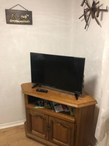 een flatscreen-tv bovenop een houten kast bij chez salome et fritz in Ingolsheim