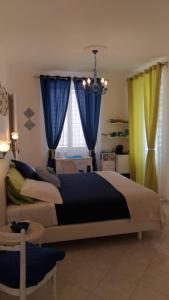 1 dormitorio con 1 cama grande con cortinas azules y amarillas en Sorrento Penthouse Suites en Sant'Agnello