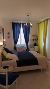 a bedroom with a large bed with blue and yellow curtains at Sorrento Penthouse Suites in Sant'Agnello
