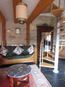 sala de estar con sofá y escalera de caracol en Gite les Camélias, en Sainte-Anne-sur-Vilaine