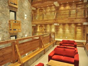 a room with two red chairs and wooden walls at Bianca Resort & Spa in Kolašin