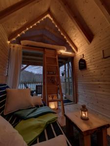 a bedroom in a log cabin with a bed and a table at Riverland in Gornji Zvečaj
