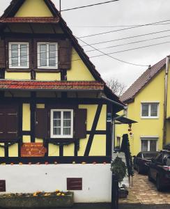 a yellow and black house in a street at chez salome et fritz in Ingolsheim