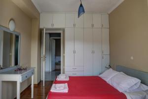 Kokkínion的住宿－HOUSE ALEXANDER，一间卧室配有一张带红色毯子的床