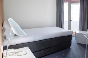 a hotel room with a bed and a desk with a desk at Stay Hotel Faro Centro in Faro