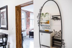 a room with a mirror and a kitchen with a counter at Apartamenty Pocztowa in Bydgoszcz