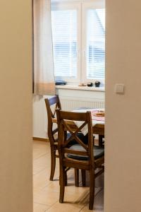 d'une salle à manger avec une table, des chaises et une fenêtre. dans l'établissement Apartmány Hrady, à Zuberec