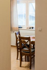 a dining room with a table and chairs and a window at Apartmány Hrady in Zuberec