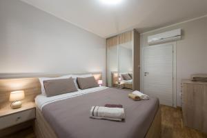 a bedroom with a large bed with two towels on it at EdiLux in Kotor